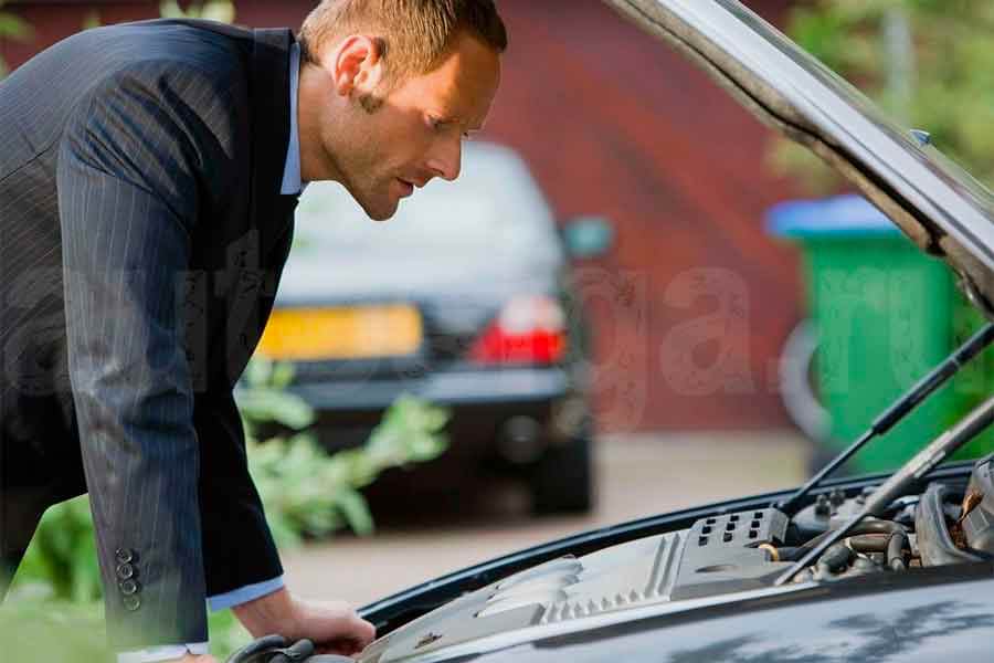 Покупатель осматривает подержанный автомобиль